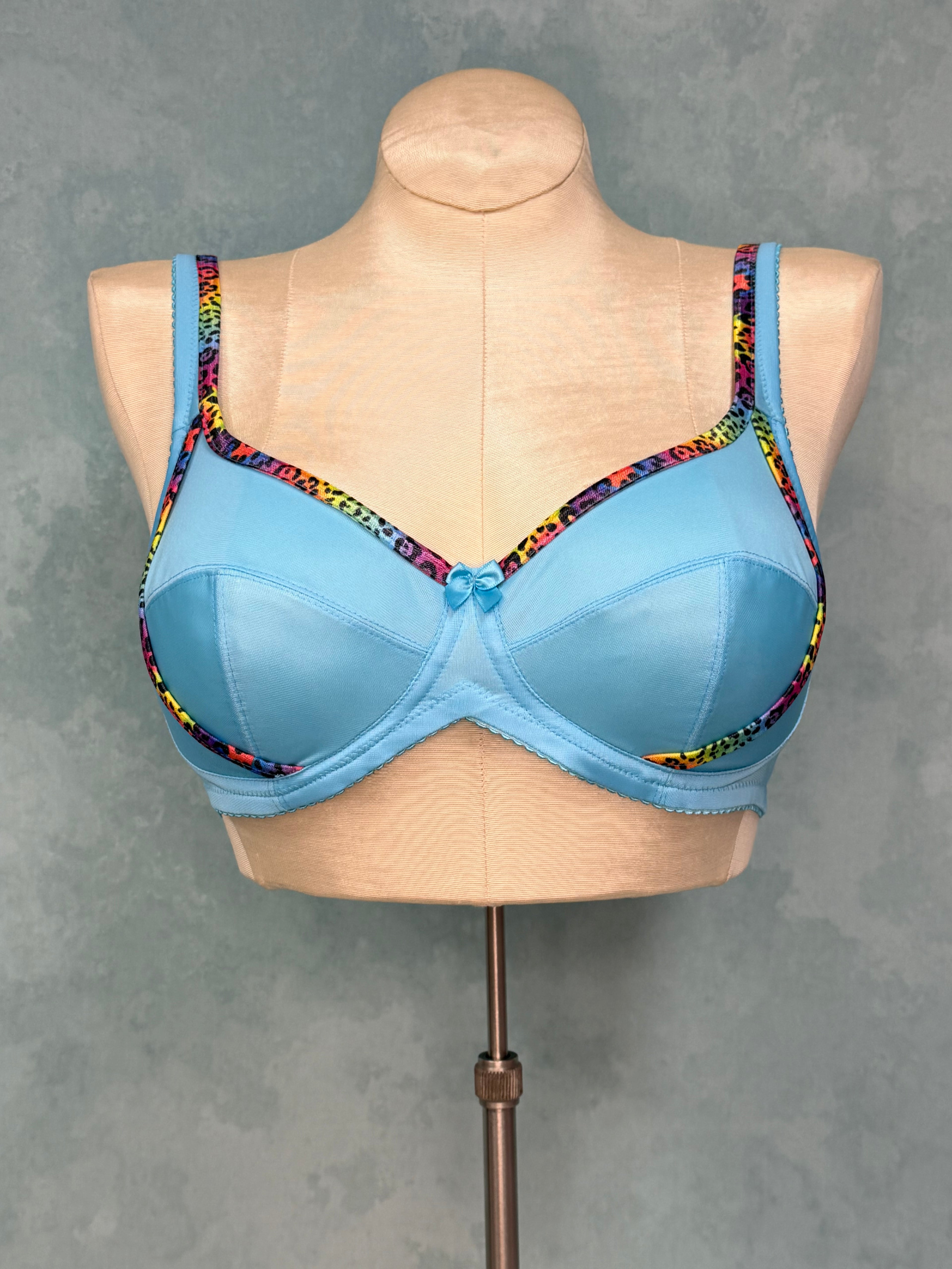 Blue bra with colorful trim on a mannequin against a gray background