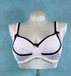 White bra with black accents on a mannequin against a blue background