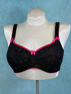 Black and pink lingerie set on a mannequin against a light blue background