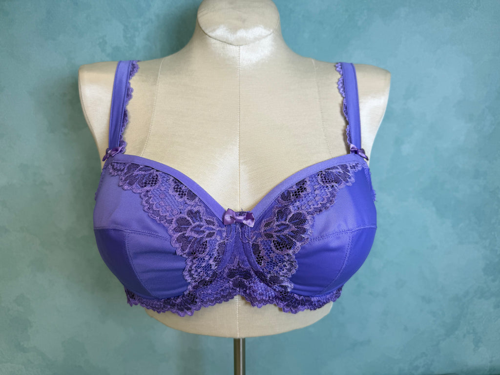 Purple bra with lace details on a mannequin against a teal background