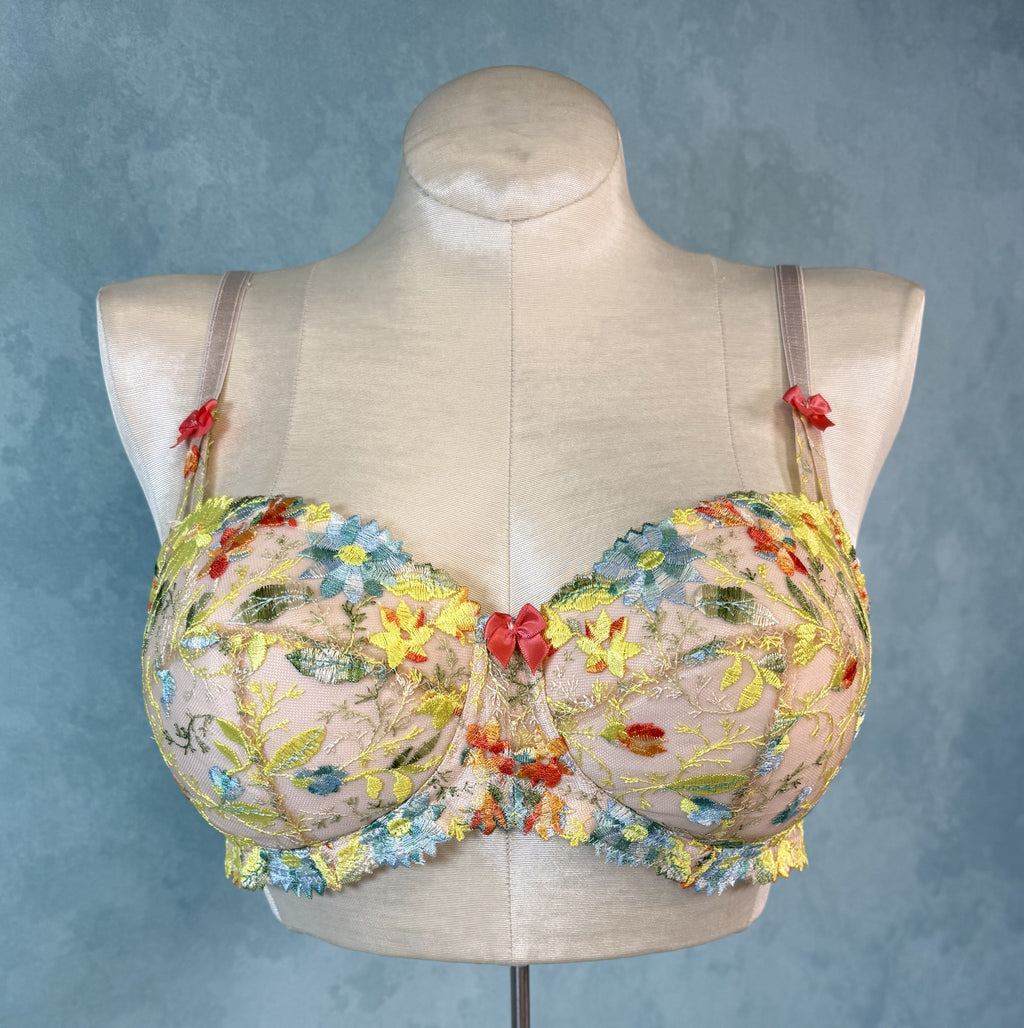 Floral embroidered bra on a mannequin against a blue background