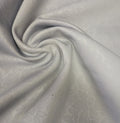 A swatch of laminated, non-stretch embossed light grey fabric.